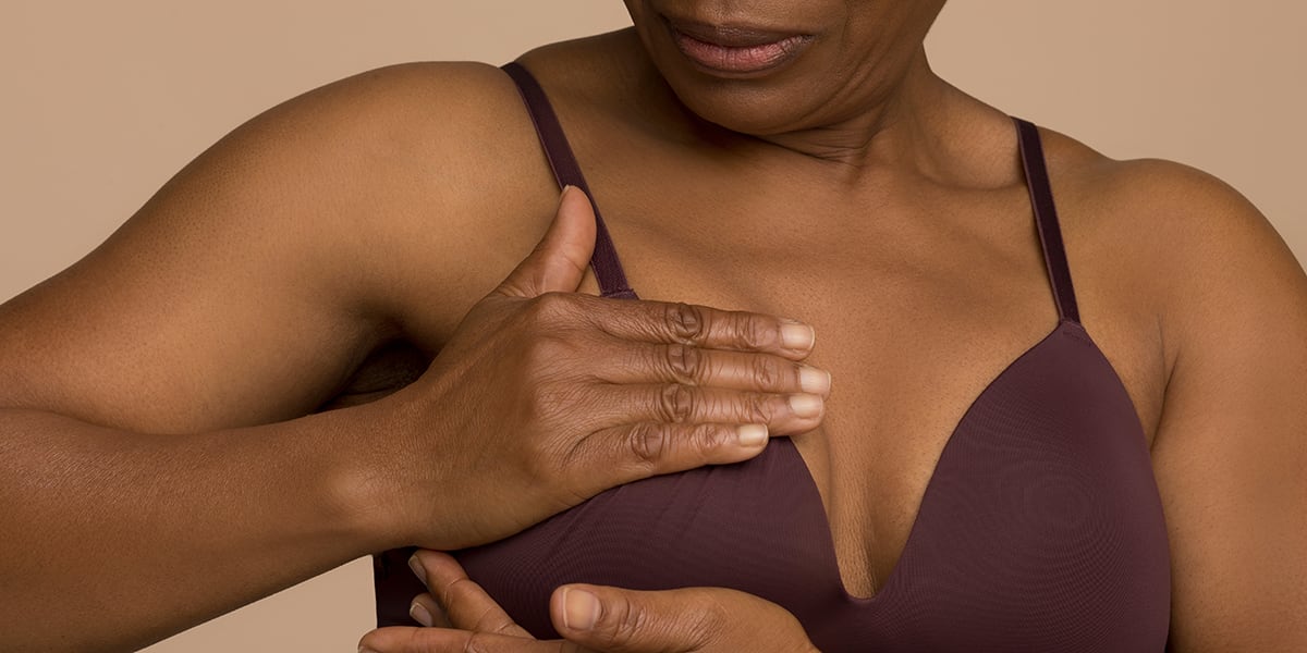 Frau tastet Brust nach Brustkrebs ab